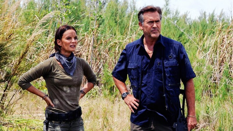 Fiona Glenanne (Gabrielle Anwar) und Sam Axe (Bruce Campbell) verfolgen einen Verdächtigen bis in ein hochgesichtertes Militärcamp. – Bild: RTL /​ USA Network