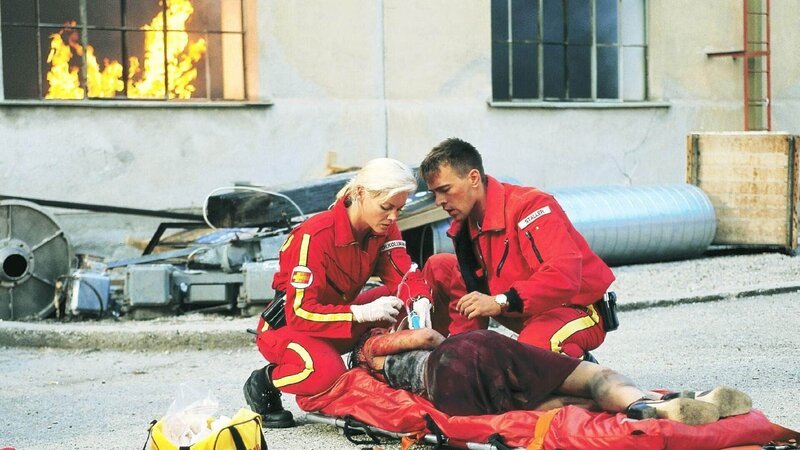 Die Notärztin Dr. Gabriele Kollmann (Anja Freese, l.) und der Sanitäter Ralf Staller (Wolfgang Krewe) kümmern sich um eine Verletzte. – Bild: RTL /​ Helene Waldner