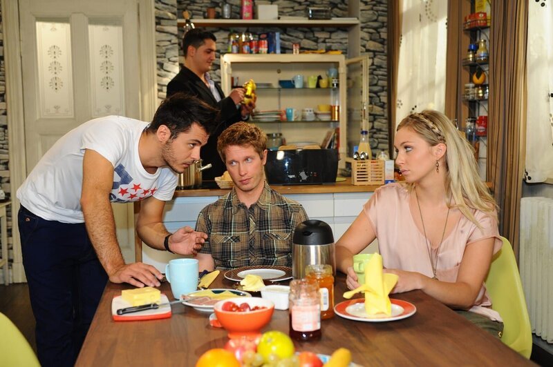 Jasmin gesteht Lily (Jil Funke, r.) und Jojo (Bernhard Bozian, M.), dass sie Khalid (Darsteller unbekannt, hinten) nur erfunden hat, um ihnen die Trennung leichter zu machen. Sie macht schweren Herzens mit ihnen Schluss. Jojo und Lily versuchen sich mit dem Gedanken, wieder zu zweit zu sein, anzufreunden, als plötzlich Maik (Sebastian König, l.) mit einem fremden Mann in der Küche der WG steht: Khalid! – Bild: SAT.1