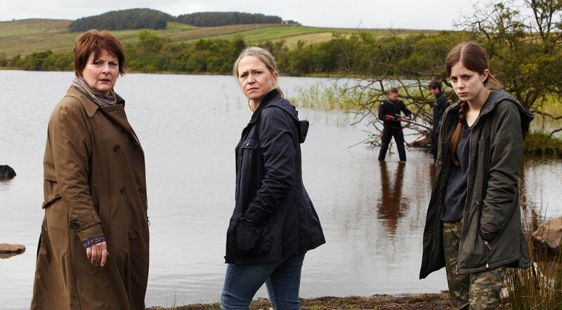 Vanessa Barnes (Kellie Bright, M.) hat zusammen mit ihrem Bruder zufällig Shane Thurgood tot aufgefunden, der durch einen Kugelschuss ums Leben kam. DCI Vera Stanhope (Brenda Blethyn, l.) ermittelt am Tatort – der Moorlandschaft von Northumberland. Im Bild mit Saskia Barnes (Charlotte Hope, l.). – Bild: ITV GLOBAL