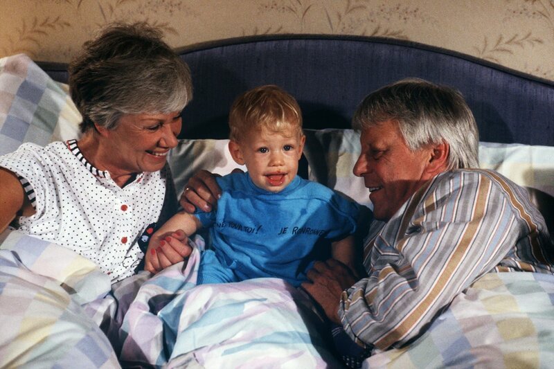 Ein seltener, aber diesmal ganz besonders gern gesehener Gast im Ehebett der Großeltern Hannelore (Maria Sebaldt, l.) und Eberhard (Stephan Orlac, r.) ist der wieder gesunde kleine Thomas (Jean Michel Cortes). – Bild: ZDF und Terranova