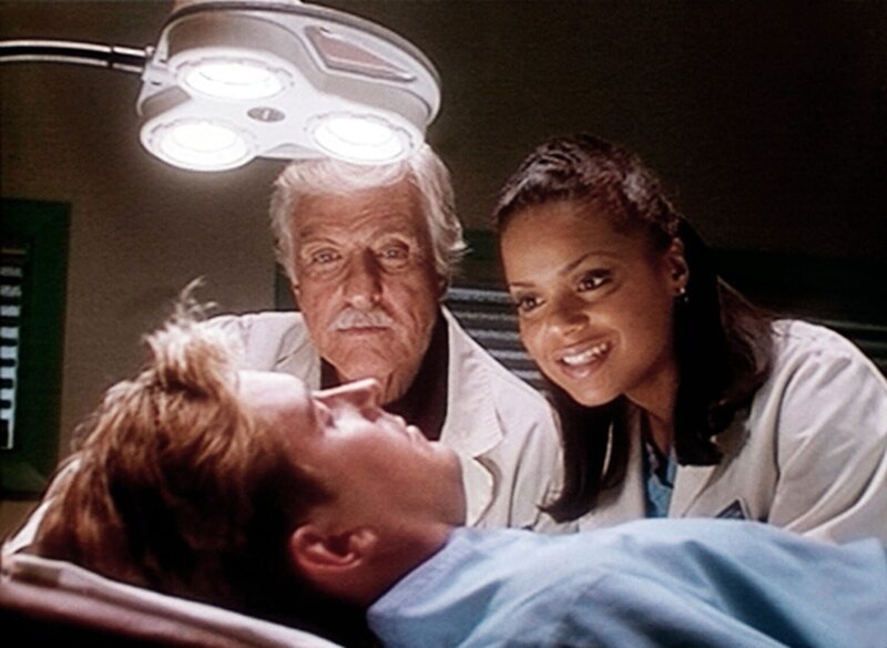 Mark (Dick Van Dyke, M.) und Amanda (Victoria Rowell, r.) amüsieren sich über Jesse (Charlie Schlatter, vorne), der im OP eingeschlafen ist. – Bild: Viacom