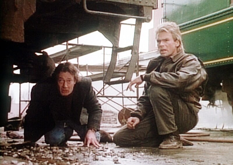 Nelson Richardson (Andrew Rhodes, l.) bringt MacGyver (Richard Dean Anderson, r.) zu dem Videoband, das er in einem alten Waggon versteckt hat. – Bild: Kabel Eins Classics