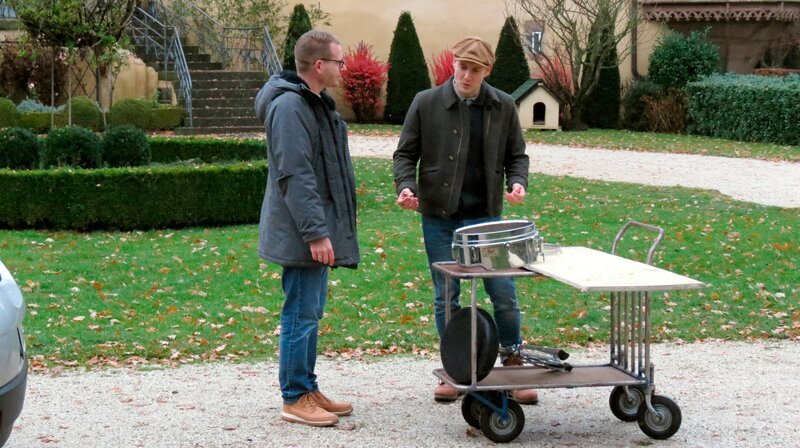 Chris (l) hat Oli P. eine Snare-Drum und ein altes Schalbrett mitgebracht. – Bild: WDR/​Encanto Film- und Fernsehproduktions GmbH