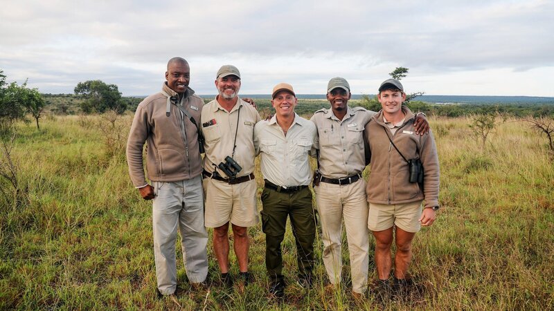 Moderator Rob Rinder mit einigen Rangers des Phinda Private Game Reserve in Südafrika – Bild: SRF/​BBC Studios