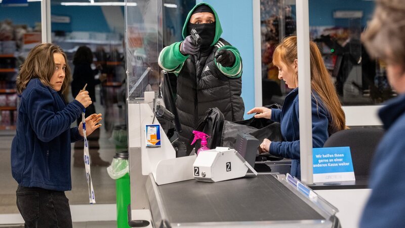Überfall auf einen Discounter. Der Täter im grünen Jogginganzug bedroht die Angestellten. Doch dann stören Zeugen die Tat. – Bild: ZDF und Saskia Pavek