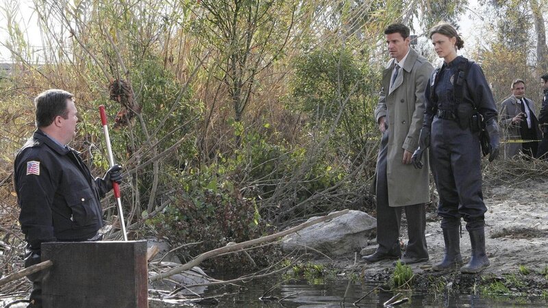 Booth (David Boreanaz, Mi) und Brennan (Emily Deschanel) untersuchen den Tatort, an dem eine Frau, ohne Knochen und in einer Kiste verpackt, im Fluss gefunden wurde. – Bild: MG RTL D /​ Fox