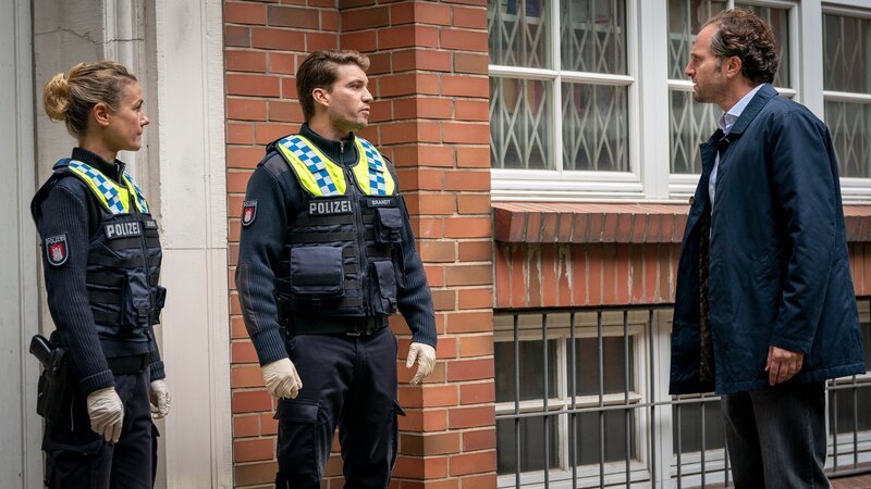 Franzi (Rhea Harder-Vennewald, l.) und Nick (Raúl Richter, M.) berichten dem Apotheker Ayman Amani (Saro Emirze, r.) von dem Überfall auf dessen Angestellte Sandra Mertens. – Bild: ZDF und Boris Laewen