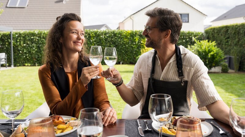 Marie (Tinka Fürst, l.) und Guideon (Tom Beck, r.) beim harmonischen Grillabend: Zwischen strahlenden Blicken und perfekt mariniertem Essen scheint Guideon einmal mehr alles richtig zu machen. – Bild: ZDF
