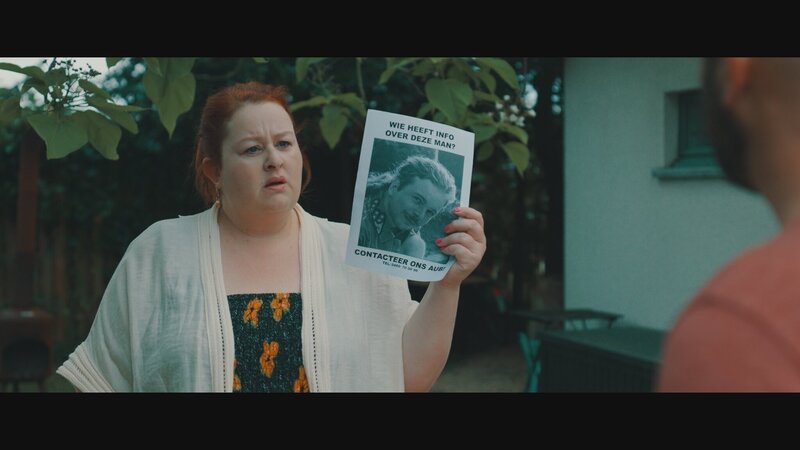 Die Suchaktion läuft auf Hochtouren: Suzanna (Eva Van der Gucht) hält einen Suchzettel hoch. – Bild: VRT/​Nico Surings