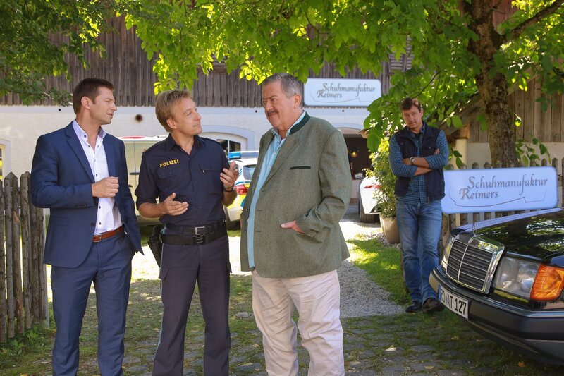 Die Mordkommission ermittelt, nachdem ein Rosenheimer Schuhmacher tot aufgefunden wurde: Kommissar Hansen (Igor Jeftic), Polizist Mohr (Max Müller) und Kommissar Hofer (Joseph Hannesschläger). Im Hintergrund: Maik Duschinsky (Markus Langer). – Bild: ZDF/​Christian A. Rieger – klick