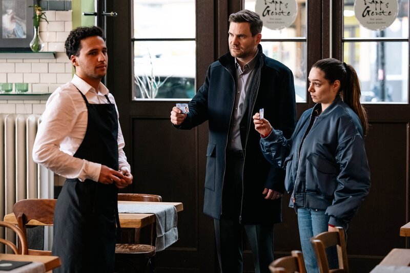 Kommissare Jonas Fischer (Lukas Piloty, M.) und Amira Mahdi (Aylin Ravanyar, r.) besuchen das Restaurant des Opfers und treffen dort auf Murat Akinci (Mo Issa, l.). – Bild: ZDF und Martin Rottenkolber