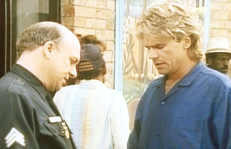 MacGyver (Richard Dean Anderson, r.) berichtet dem Polizisten (John Hostetter, l.), was er bei der Entführung der Studentin beobachtet hat. – Bild: ProSieben Media AG