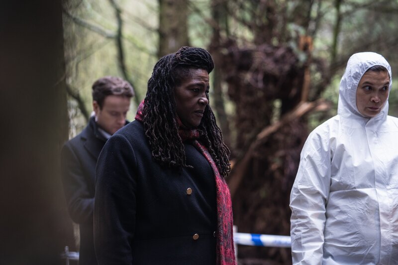 Harper (Andrew Gower, l.) und Ellis (Sharon D Clarke, M.) stehen mit der Gerichtsmedizinerin CSI Christine Bennett (Kirsten Foster, r.) am Leichenfundort, einem Waldstück. – Bild: Steffan Hill, Peter Marley /​ ZDF