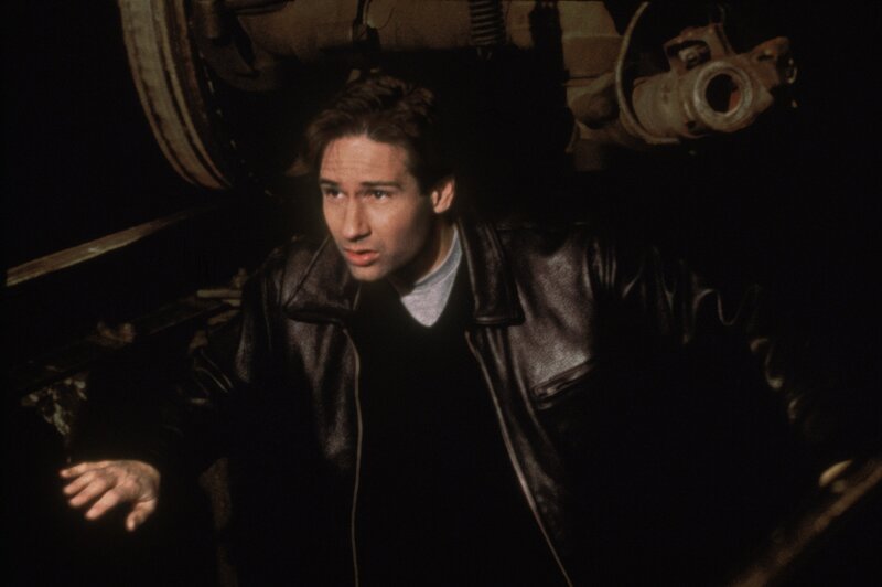 Mulder (David Duchovny) verfolgt einen Eisenbahnwaggon der amerikanischen Regierung, in dem ein lebender Außerirdischer transportiert wird. – Bild: 1995⁠–⁠1996 Twentieth Century Fox Film Corporation. All rights reserved. Lizenzbild frei