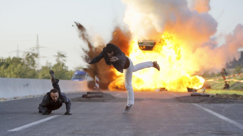 Semir (Erdogan Atalay, l.) und Ben (Tom Beck) bringen sich in letzter Sekunde vor dem explodierenden Streifenwagen in Sicherheit … – Bild: Guido Engels