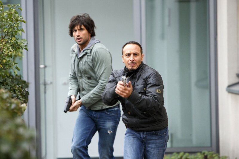 Als der flüchtige Drogenkurier vor ihren Augen ermordet wird, nehmen Ben (Tom Beck, l.) und Semir (Erdogan Atalay) die Verfolgung auf. – Bild: RTL /​ Guido Engels