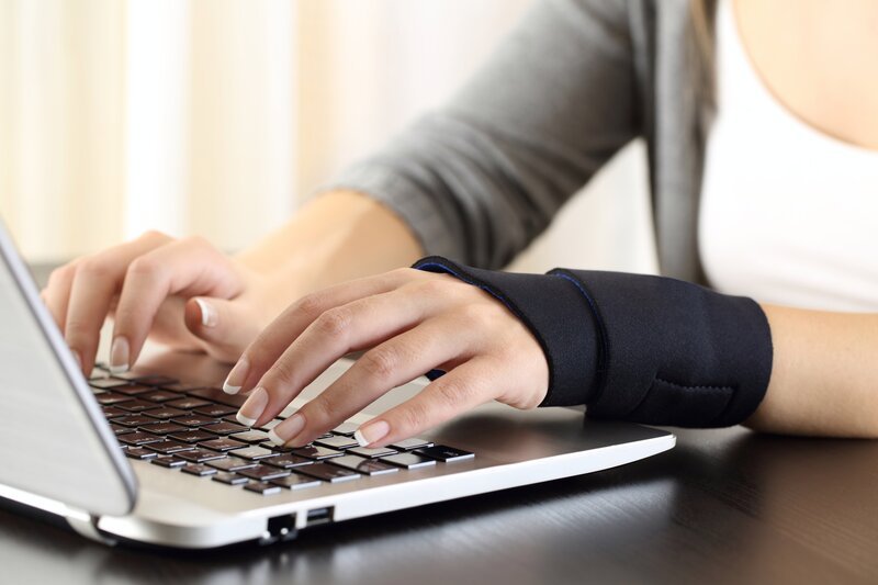 Stockfotografie: Frauenhände mit verletztem Handgelenk arbeiten am Netz – Bild: depsoitphotos