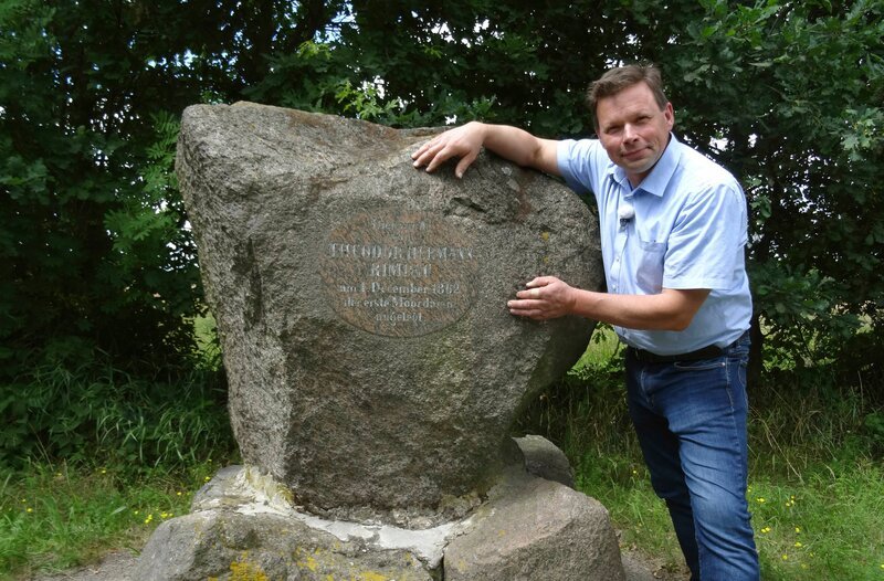 Tilmann Schwartzkopff, Landwirt im Drömling, am Gedenkstein für den ersten Moordamm. Mit diesem Verfahren hat sein Vorfahre Theodor Hermann Rimpau ab 1862 die landwirtschaftlichen Erträge immens gesteigert. – Bild: MDR/​Heiko Kunzmann
