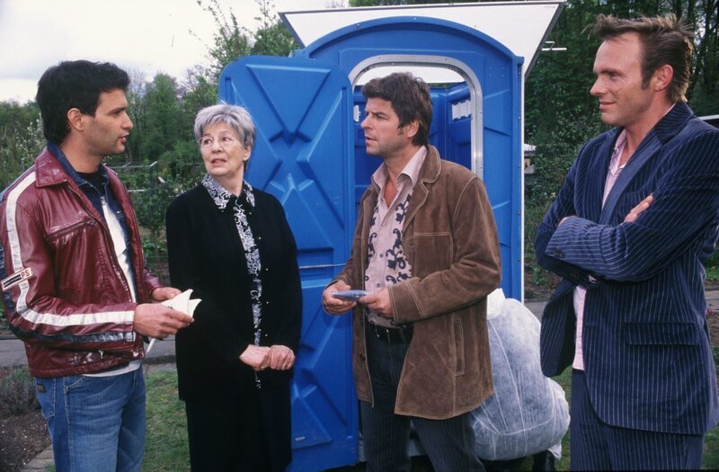 Die Beamten Jupp (Uwe Fellensiek, 2.v.r.), Falk (Dirk Martens, r.) und Gino (Luca Zamperoni, l.) untersuchen den Tatort und befragen Frau Moll (Ilse Strambowski, 2.v.l.), die die Leiche im Dixie-Klo gefunden hat. – Bild: SAT.1 /​ Münstermann
