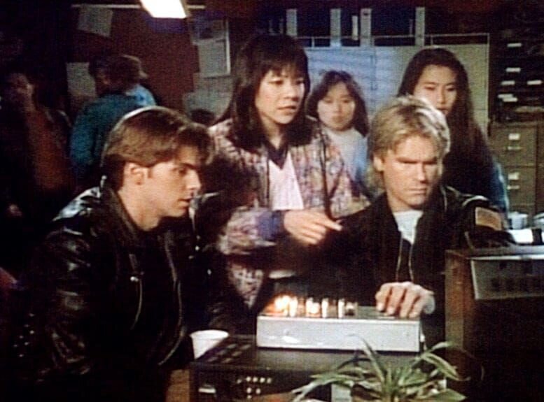 MacGyver (Richard Dean Anderson, 2.v.r.) sieht sich mit Sam (Dalton James, l.) eine Videokassette an, die die Verhältnisse in einem chinesischen Straflager dokumentiert. – Bild: ProSieben Media AG