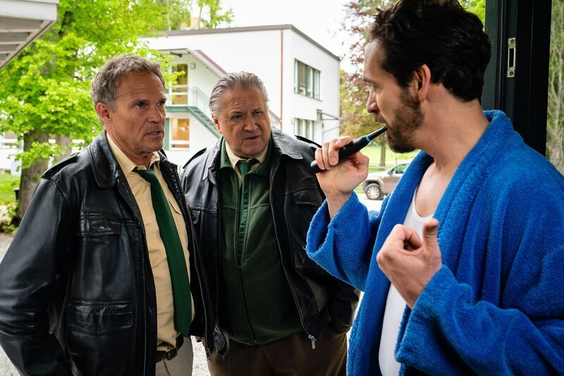 Hubert (Christian Tramitz, l.) und Girwidz (Michael Brandner, M.) befragen den Nachbarn Dr. Seidl (Markus Andreas Klauk, r.). – Bild: TMG /​ Arvid Uhlig