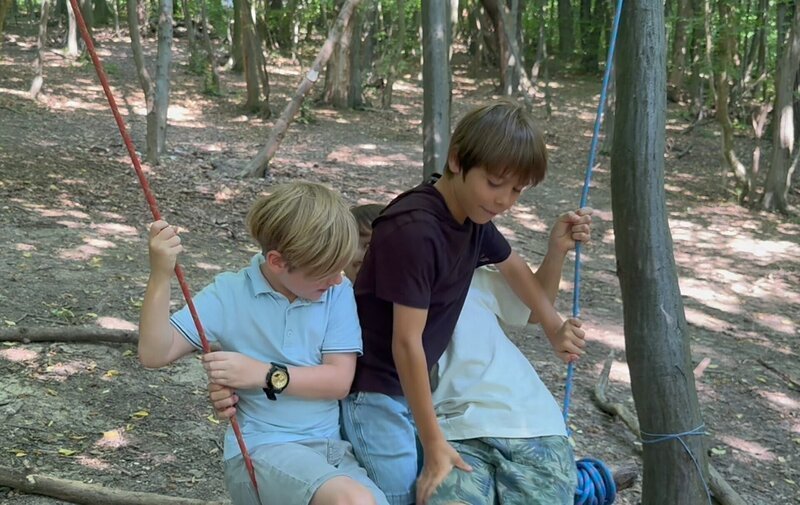 Die Abenteuer-Checker Benni, Gucki und ihr Freund Laurin beim Schaukel-Bauen im Wald. – Bild: ORF/​Mabon Film