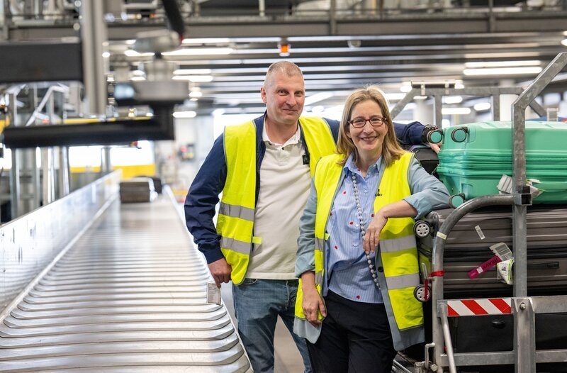 Wie bekommen Sie Ihren Koffer nach einem Flug wieder unbeschadet zurück? Verbraucherjournalistin Yvonne Willicks (r) ist dafür am Flughafen Dortmund mit Schichtleiter Heiko Rothkugel verabredet und findet es heraus! – Bild: WDR/​Melanie Grande