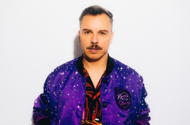 MDR FERNSEHEN PURPLE DISCO MACHINE – FROM DRESDEN TO THE WORLD, am Donnerstag (28.03.24) um 23:00 Uhr. Purple Disco Machine ist einer der weltweit erfolgreichsten DJ’s und Produzenten – ein Star der Electronic dance music. Ob Ibiza oder Coachella Festival, Mexiko City, Austin, Hongkong oder New York, wo er angekündigt ist, füllt er Arenen. Bekannt wurde der Dresdener mit Remixes für andere Stars : Sir Elton John, Lady Gaga, Dua Lipa, Fatboy Slim,  Gorillaz, Jamiroquai oder Diplo.  Doch mit eigenen Hits wie „Hypnotized“, „Dopamin“, oder „Fireworks“ hat er inzwischen bei Spotify mit einer Milliarde Streams mehr als Rammstein und Helene Fischer zusammen.  Nur wenn er nach Hause kommt, bleibt er anonym. Dann ist er Tino Piontek, 42 Jahre alt, verheiratet und Vater, ein nahezu ganz normaler Dresdener. Wer dieser Mann ist und wie er so erfolgreich wurde, was seine Heimat Dresden, Phil Collins und seine Oma damit zu tun haben, davon erzählt dieser Film.  Purple Disco Machine (Tino Piontek) – Bild: MDR/​Fiona Garden