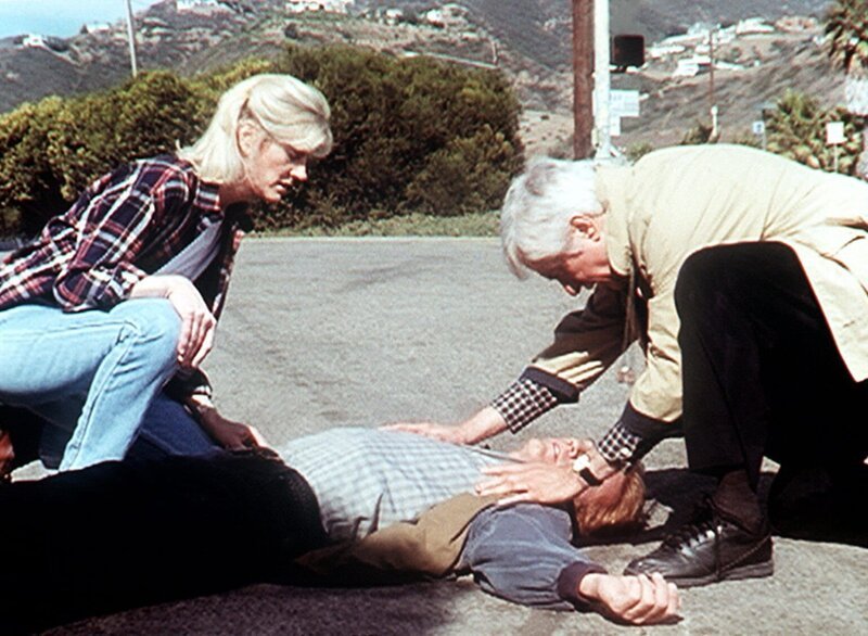 Steve (Barry Van Dyke, liegend) ist von einem flüchtenden Gangster angefahren worden. Dr. Mark Sloan (Dick Van Dyke, r.) und Carol (Stacy Van Dyke) leisten erste Hilfe. – Bild: Sat.1 Gold