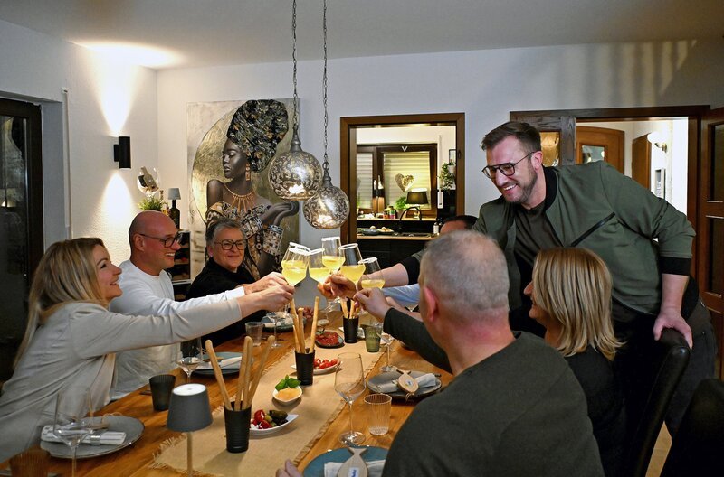 Sören Anders (re.) stößt mit der ganzen Familie Blonski-Nett auf ein gelungenes Essen an. – Bild: SWR/​Kristina Schäfer