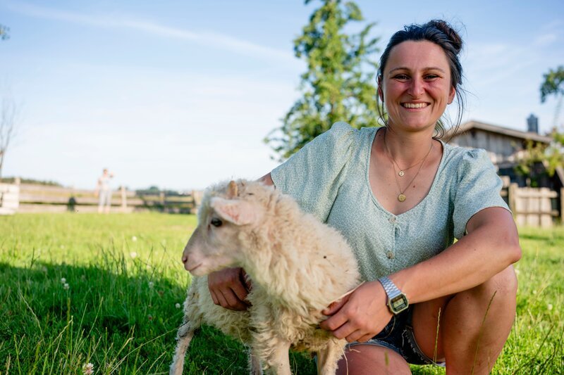 Anja steht mit ihrem kleinen Schaf auf einer Wiese. – Bild: Moritz Sonntag /​ BR, megaherz gmbh /​ BR/​megaherz gmbh/​Moritz Sonntag