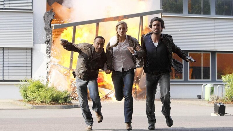 Semir (Erdogan Atalay, l.) und Ben (Tom Beck) können Claudia (Julie Engelbrecht) in letzter Sekunde aus dem Forschungsinstitut retten, bevor dieses explodiert … – Bild: TVNOW /​ Guido Engels