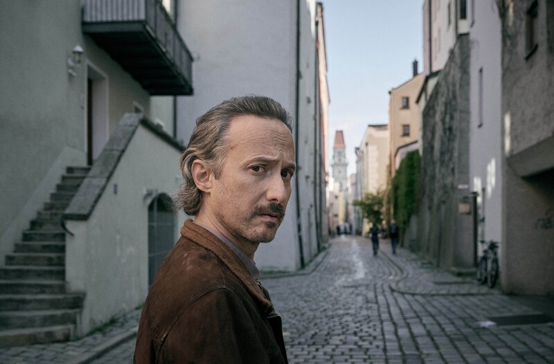 Ferdinand Zankl (Michael Ostrowski) in der Straße von seiner Detektei. – Bild: BR/​ARD Degeto Film/​Hager Moss Film GmbH/​Bernd Schuller