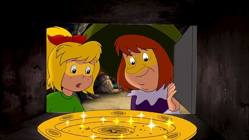 Walpurgia (r.) zeigt Bibi (l.) die goldene Schale mit Sternenstaub. – Bild: ZDF/​Kiddinx