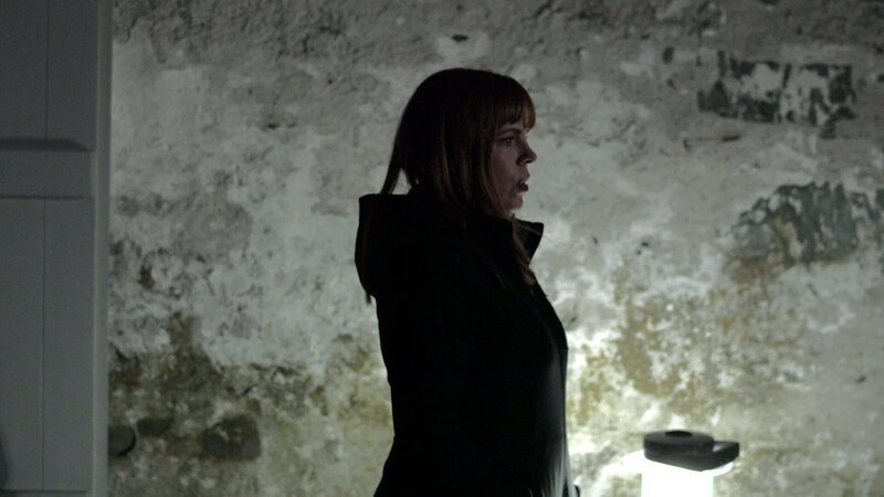 After hearing a rustle behind her, paranormal investigator Amy Bruni takes one last look back at the lighthouse before heading into the barracks on the other side of the island. – Bild: Travel Channel
