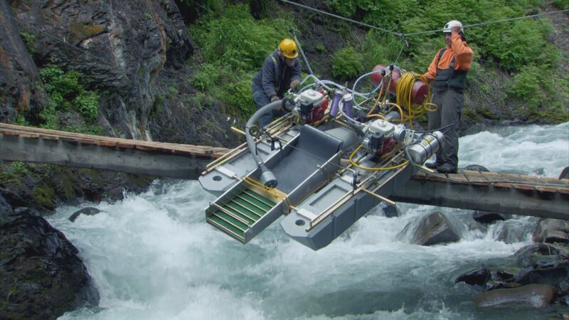 L-R: Fred Hurt and Carlos in the freezing McKinley Creek. – Bild: Warner Bros. Discovery
