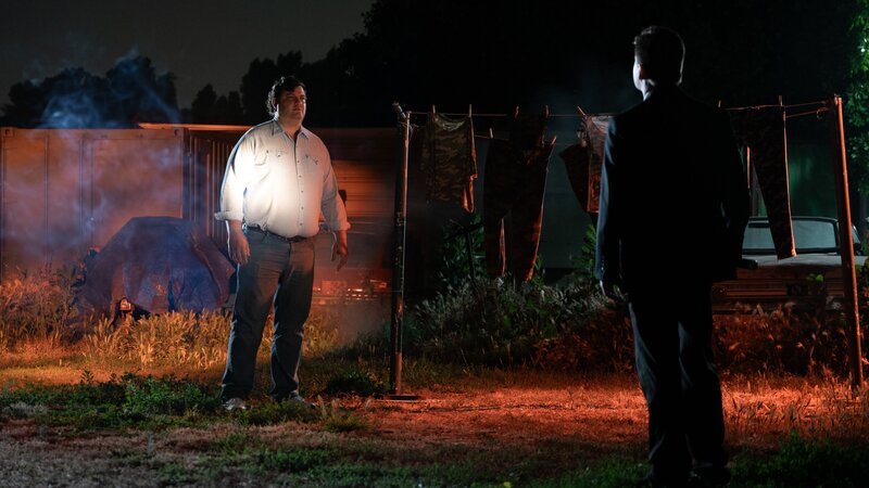 RECREATION – Homicide Lead Investigator Deckard (Peter Mastine) talks with Gerald Cruz (Paul Anthony Turner) at The Camp, by camouflage clothes hanging on clotheslines. – Bild: Warner Bros. Discovery