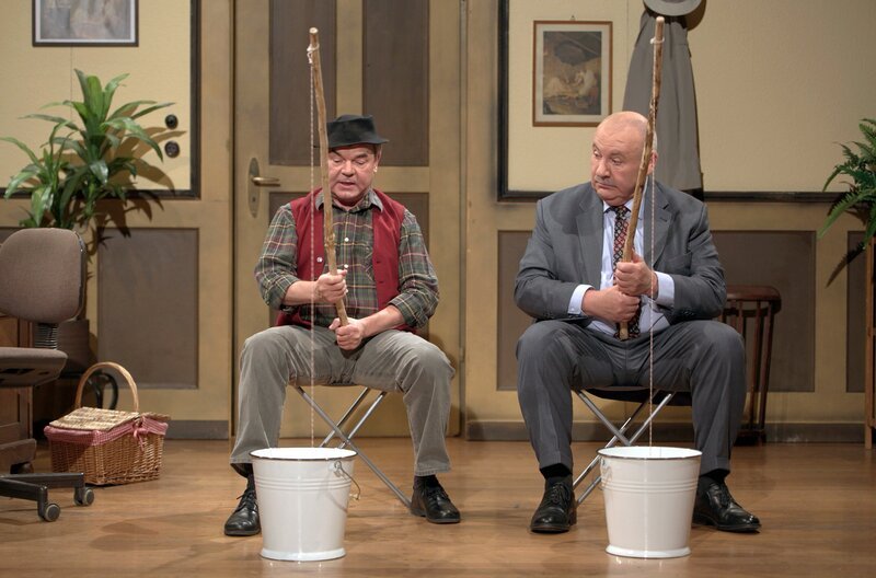 Eigentlich wollte der Bürgermeister (Karlheinz Hartmann, re.) mit seiner Frau nach China reisen, hat sich aber dann doch für einen ruhigen Urlaub zu Hause entschieden. Mit seinem Amtsboten Hannes (Albin Braig, li.) genießt er nun die Ruhe im Rathaus und die Vorzüge des heimischen Vespers, ohne Stechfliegen, bzw. „Stupfmucken“ wie Hannes diese Plagegeister nennt. – Bild: SWR/​braig-productions /​ SWR Presse/​Bildkommunikation