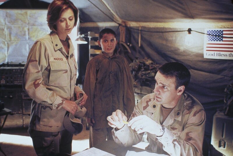 Lieutenant Colonel Sarah MacKenzie (Catherine Bell, l.) hat einen afghanischen Jungen gefunden, der als Automechaniker arbeitet. Commander Harmon Rabb jr. (David James Elliott, r.) erfährt durch ihn, dass er Kabirs Auto gewartet hat und dass Kabir in Begleitung einer Frau war. – Bild: PAT