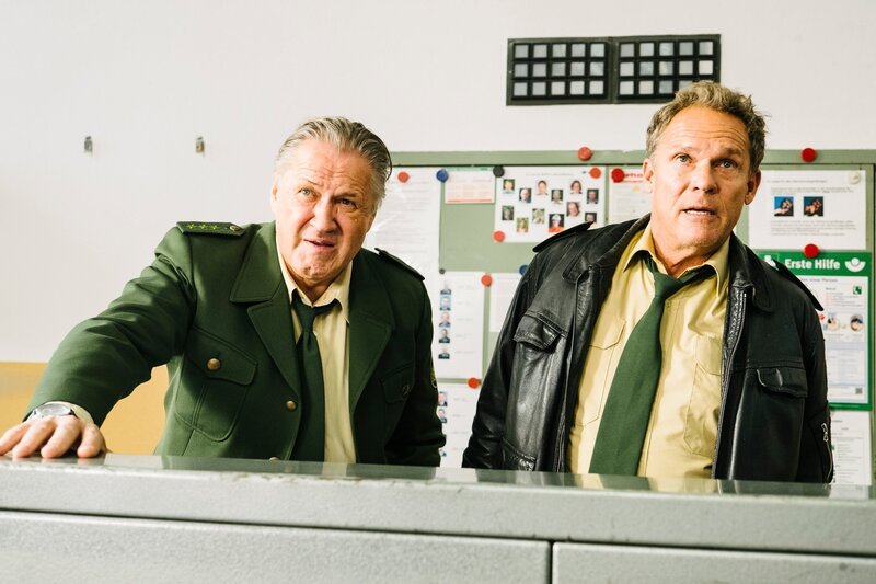 Hubert (Christian Tramitz, r.) und Girwidz (Michael Brandner, l.) übernehmen die Steuerung vom Trainingsparcour der Feuerwehr. – Bild: TMG /​ Emanuel Klempa