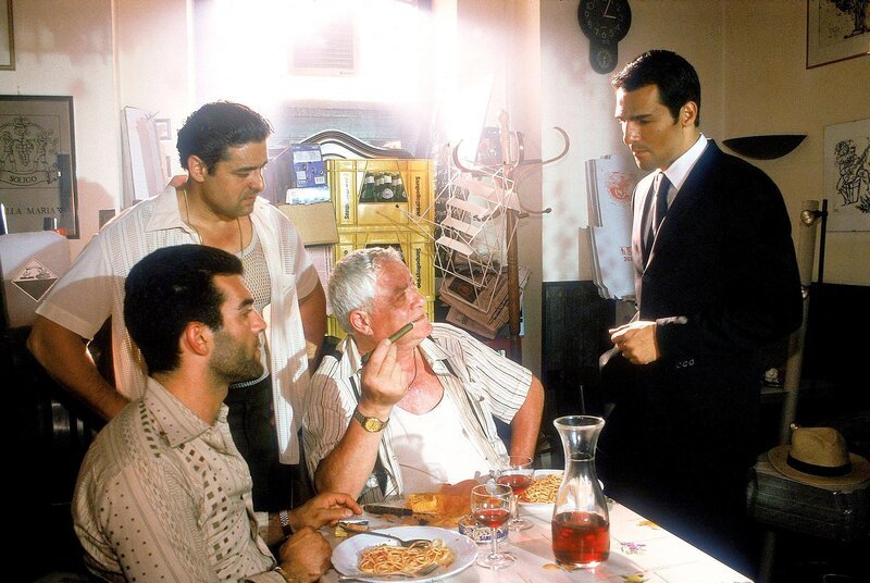 Kommissar Toprak (Erol Sander, re.) fragt Guiseppe Grasso (G. Mario Donatone, 2.v.re.), ob der ermordete Lorenzoni ab und zu dienstlich für ihn unterwegs war, obwohl dieser nicht Grassos Clan angehört. – Bild: ORF/​Elke Werner