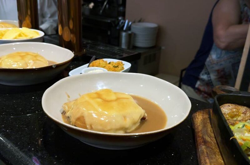 Die traditionsreiche Francesinha besteht aus Toastbrot, mehreren Fleischsorten sowie geschmolzenem Käse und wird mit brauner Soße serviert. – Bild: Elephant Doc