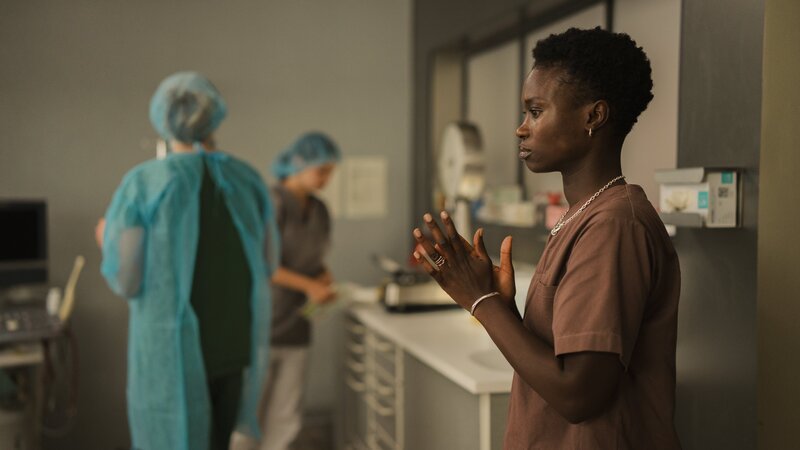 Tara (Lorna Ishema, r.) ist nervös: Gleich wird sie zum ersten Mal eine Geburt miterleben. Nach ihrer Krebserkrankung kann sie selbst keine Kinder bekommen. Fritzi Hafer (Llewellyn Reichman, l.) und Irina Petrenko (Katja Hutko, M.) bereiten alles für die PDA der Gebärenden Sibel vor. – Bild: Clara Marnette /​ ZDF und Clara Marnette