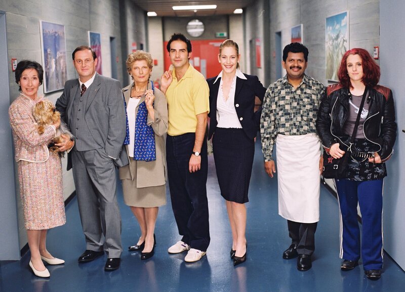 V.l.: Trudi Roth als Adele Wehrli mit Fleurettli, Christoph Sommer als Dr. Wilhelm Wehrli, Sibylle Courvoisier als Theres Bütikofer, Beat Marti als Adrian Furrer, Stephanie Japp als Verena Probst, Anton Ponrajah als Tami und Gina Durler als Chick. – Bild: Daniel Ammann /​ SF DRS /​ SRF
