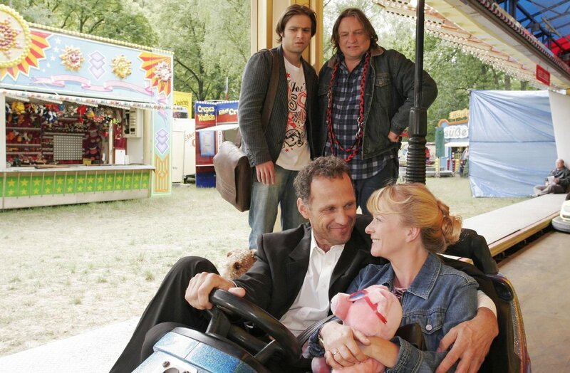 Bernd (Volker Herold, hinten r.) kocht vor Eifersucht als er mit Bruno (Tim Sander, hinten l.) seine Helga (Ulrike Mai, r.) mit ihrer Jugendliebe Martin (Peter Raffalt, l.) auf dem Rummel entdeckt. – Bild: SAT.1 /​ Noreen Flynn