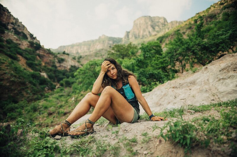 Eva sits on the edge of a rock with handmade running sandals on. – Bild: NGC NETWORK US, LLC /​ Josh Monie
