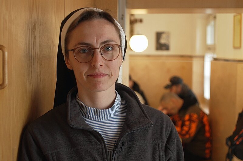 Das Kloster setzt sich seit seinen Ursprüngen für Bedürftige ein. Täglich, außer sonntags, öffnet die Klosterpforte die Türen für alle, die mittags eine warme Mahlzeit benötigen. Schwester Clara Marie (29) verteilt dort regelmäßig Essen. – Bild: ZDF und Anton Felixberger