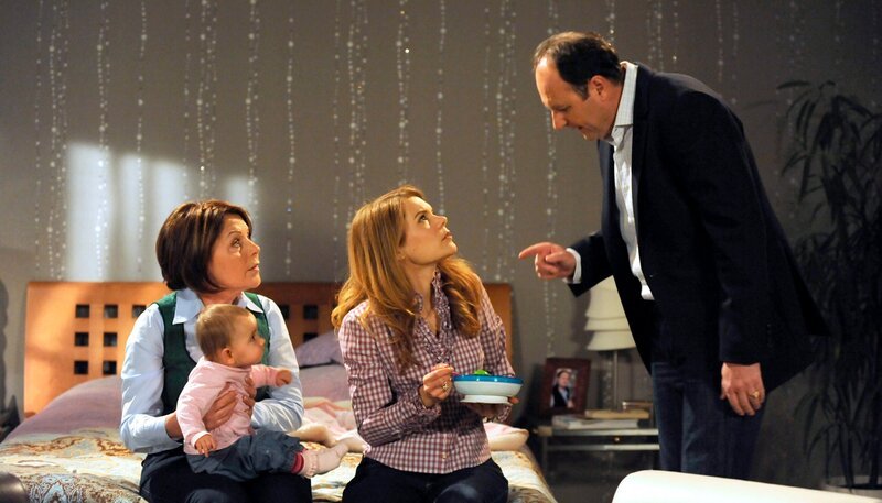 Hubert denkt, die Ursache für Franzis Allergie gefunden zu haben. Von links: Rosi Brunner (Brigitte Walbrun), Baby Franzi (Franzi), Uschi Guggenmoser (Silke Popp) und Hubert Kirchleitner (Bernhard Ulrich). – Bild: BR/​Marco Orlando Pichler