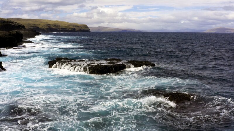 Eine schroffe Steilküste, geformt aus Basalt und Vulkangestein, so ragen die Färöerinseln aus dem Meer und trotzen dem stürmischen Nordatlantik. Grasbewachsene Berghänge, Wasserfälle und kleine Bäche prägen die Landschaft. – Bild: ORF/​Autentic